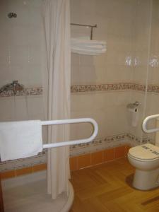 y baño con aseo y cortina de ducha. en Hotel Rural Puerto Mágina, en Torres 37 fotos más