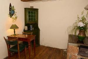 a room with a table and chairs and a green cabinet at Kurte in Talsi