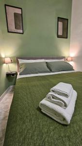a green bedroom with a bed with towels on it at Gliù Vico in Formia +115 photos