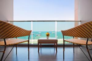 a room with two chairs and a table and a large window at Balihai Bay Pattaya in Pattaya South