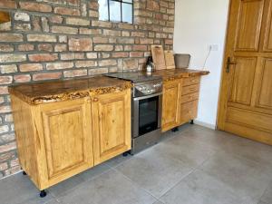 a kitchen with a stove and a brick wall at Mariska in Balatonkeresztúr