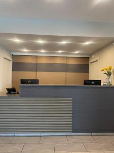 a lobby with a reception counter with flowers on it at Plantation Inn in Houma