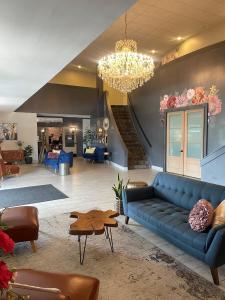 a living room with a blue couch and a chandelier at Plantation Inn in Houma