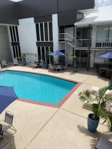 a swimming pool in front of a building at Plantation Inn in Houma
