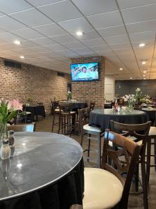a dining room with tables and chairs and a tv at Plantation Inn in Houma