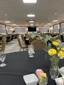 a conference room with tables and chairs with yellow flowers at Plantation Inn in Houma