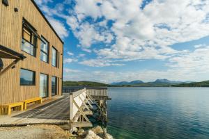 a house on a dock next to a body of water at Steam Pier Adventure Hotel in Tromsø