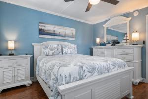 ブレイデントン・ビーチにあるAMI Condo With Pool, Walk to Beach & Bridge Stの青いベッドルーム(ベッド1台、鏡付)
