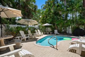ブレイデントン・ビーチにあるAMI Condo With Pool, Walk to Beach & Bridge Stの白い椅子とパラソル付きのスイミングプール +29枚の写真