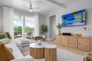 a living room with a white couch and a tv at CASA NICA! Luxury Private Pool Home with dock on a saltwater canal! in Bradenton