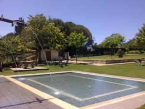 a swimming pool with a fountain in a park at Hotel Sierra Quilama in San Miguel de Valero