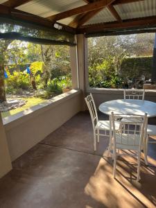 a porch with a table and two chairs on it at Mi Casita in Graskop