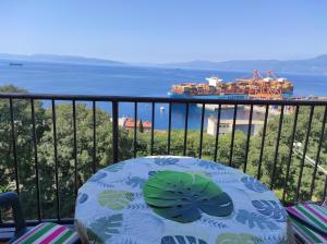 a table on a balcony with a view of the ocean at Apartman Yuriel - Sea View in Rijeka