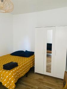 une chambre avec un lit et un miroir dans l'établissement Chambres rénovées proches de Paris Centre, des sites olympiques, avec belle terrasse calme, à Argenteuil