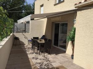 a patio with a table and chairs and a building at Maison les pieds dans L'eau à 150 m de la plage in Marseillan