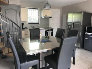 a kitchen with a dining room table and chairs at Maison les pieds dans L'eau à 150 m de la plage in Marseillan