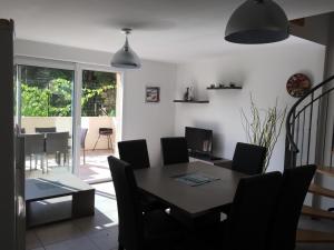 a dining room with a table and chairs at Maison les pieds dans L'eau à 150 m de la plage in Marseillan