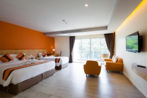 a hotel room with two beds and a window at Balihai Bay Pattaya in Pattaya South