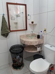 a bathroom with a toilet and a sink and a mirror at Casa Primavera in Holambra +2 photos