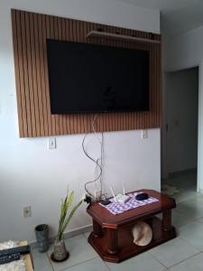a flat screen tv hanging on a wall above a table at Casa Primavera in Holambra