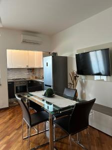 a kitchen with a table with chairs and a refrigerator at LA CASA DI AMBRA in Limbiate