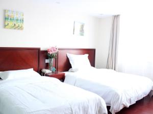 two beds in a room with white sheets at GreenTree Inn Guangdong Foshan Longjiang North Fenghua Road Express Hotel in Shunde