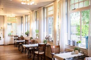 ein Restaurant mit Tischen, Stühlen und Fenstern in der Unterkunft Hotel Jans in Rijs