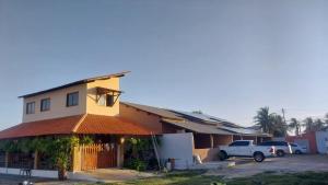 ein Gebäude mit einem LKW auf einem Parkplatz in der Unterkunft Casa de Praia in Luis Correia