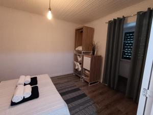 Una pequeña habitación con una cama y una ventana. en Clover's House - AL, en Algarvia