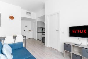 un soggiorno con un divano blu e una TV di Crocetta Charme Suite a Milano