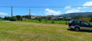a car parked in a field in front of a house at EnSan CIPRIAN Casa Lula in Cervo