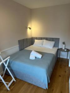 a bed with a pair of towels on top of it at Trójmiejski przystanek in Sopot +3 photos