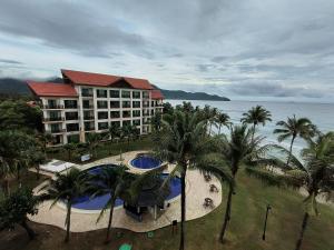 Una vista aérea de un resort con piscina y palmeras. en Olumis Nexus Apartment, en Tuaran