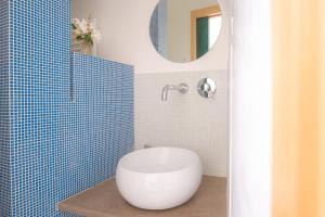 bagno con servizi igienici bianchi e parete piastrellata blu di Borgo del Mastro è la vostra vacanza bucolica! a Trevignano Romano