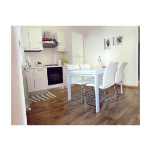a kitchen with a white table and white chairs at Dimora Azzurra in Porto SantʼElpidio