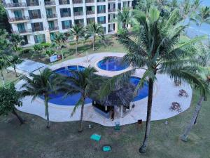 Una vista aérea de una piscina con palmeras. en Olumis Nexus Apartment, en Tuaran