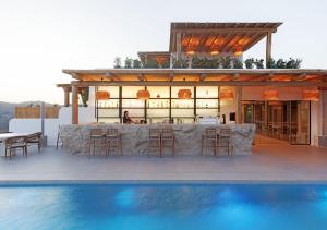 eine Bar auf dem Dach eines Hauses mit Pool in der Unterkunft WhiteArt Suites in Agrari