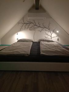 a bedroom with a bed with a tree mural on the wall at Apartment Loft Pejić - open space loft studio near Bovec, Soča Valley in Bovec