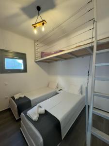 a small room with two beds and a ladder at Lilianna Tinos in Tinos