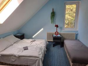 a attic bedroom with two beds and a window at Hotel Kamenný vrch in Chomutov