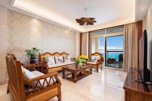 a living room with a couch and a tv at Sanya Yikehai View Apartments in Sanya
