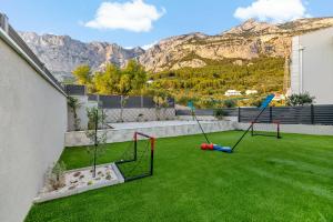 a backyard with two swings on the grass at Villa Magnus in Makarska