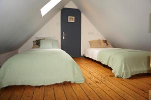 two beds sitting next to each other in a attic at Ma petite maison bretonne in Guimiliau