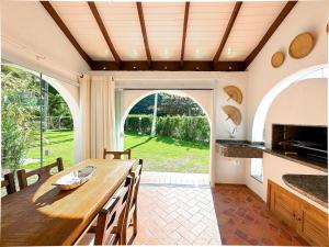 a kitchen with a wooden table and a large window at Apto estilo casa em condomínio com piscina na beira da praia in Florianópolis +24 photos