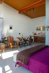 a bedroom with a large bed and a kitchen at Cabana com jacuzzi e churrasqueira - Ibiuna SP in Lajeado do Salto