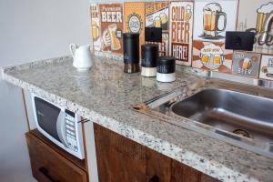 a kitchen counter with a sink and a microwave at Cabana com jacuzzi e churrasqueira - Ibiuna SP in Lajeado do Salto +19 photos
