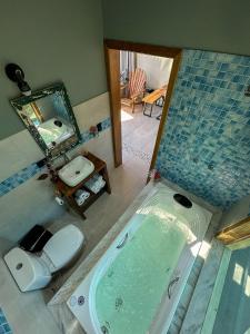 a bathroom with a tub and a toilet and a sink at Cabana com jacuzzi e churrasqueira - Ibiuna SP in Lajeado do Salto
