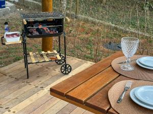a table with a grill on top of a wooden deck at Cabana com jacuzzi e churrasqueira - Ibiuna SP in Bairro Murundu