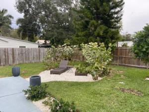 a backyard with a chair and a tree and a fence at Florida Gulf Coast Luxury Oasis in St Petersburg