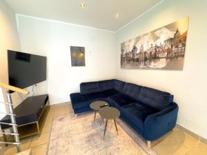 un salon avec un canapé bleu et une table dans l'établissement Citynah, Balkon, große Küche und Garten, à Hanovre